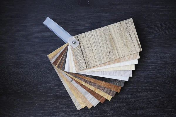 Laminate wood texture floor :oak tile, maple tile, chestnut tile, walnut tile, balsam tile,   Samples of laminate and vinyl floor tile on wooden Background. Laminate use in the house, Hospital, Townhouse, Condominium, Hotel, Apartment, Department Stock Image