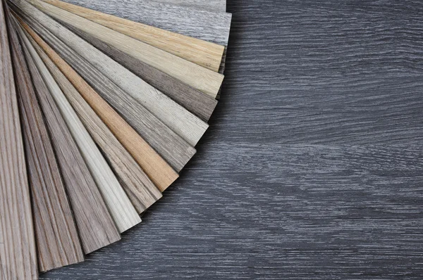 Laminate wood texture floor :oak tile, maple tile, chestnut tile, walnut tile, balsam tile,   Samples of laminate and vinyl floor tile on wooden Background. Laminate use in the house, Hospital, Townhouse, Condominium, Hotel, Apartment, Department Stock Image